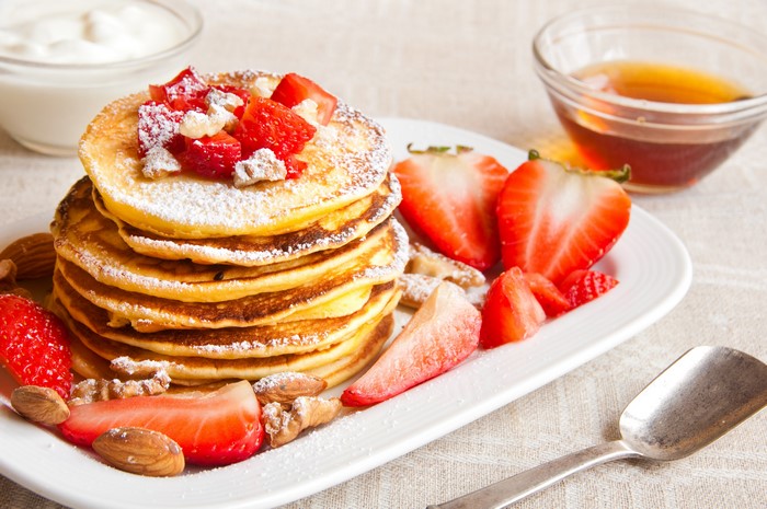 Pancakes with strawberries, nuts, and honey