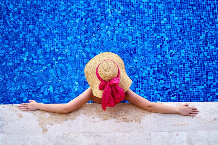 Woman in straw hat resting in a pool