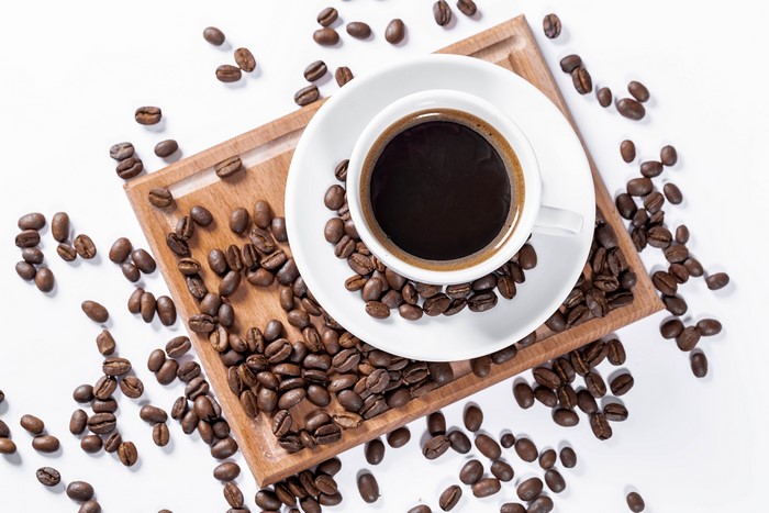 Coffee cup with beans on white background