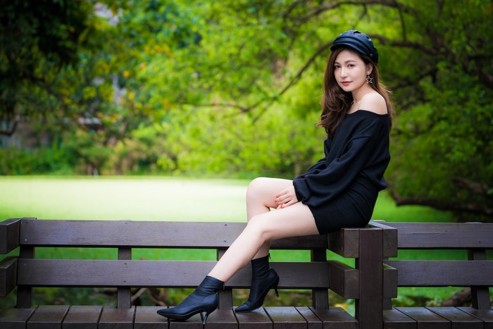 Asian woman sitting on a bench in a park