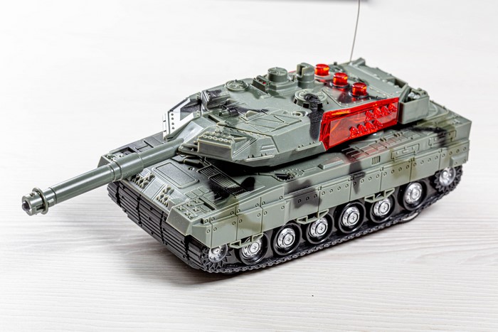 Toy tank with red lights on white background
