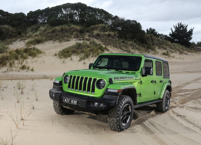 Green Jeep Wrangler Rubicon on sand dunes