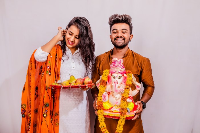 Indian couple with Ganesha idol and fruits