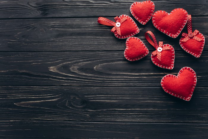Red felt hearts on dark wood planks