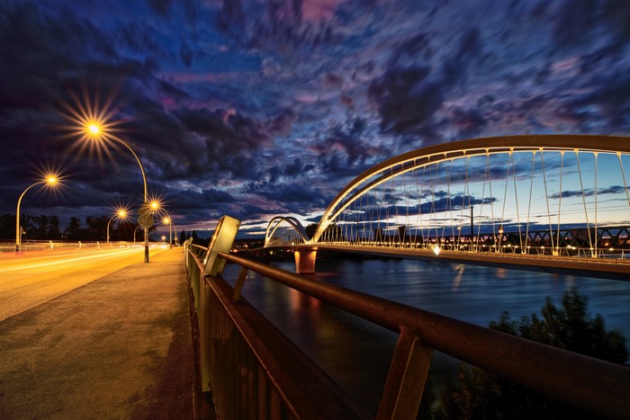 Bridge over river at dusk with streetlights