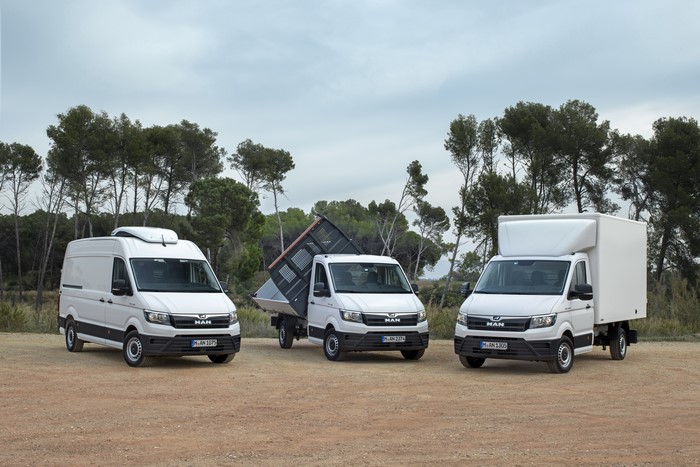 Three white MAN TGE trucks