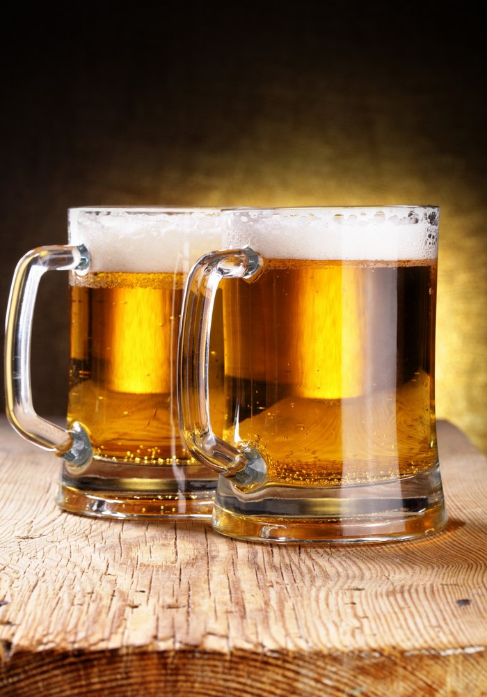 Two mugs of beer on wooden planks