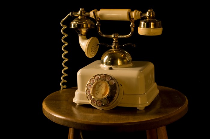 Retro rotary telephone on a wooden stool