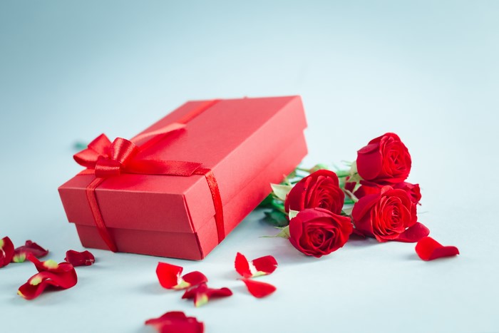 Red gift box with red roses and petals
