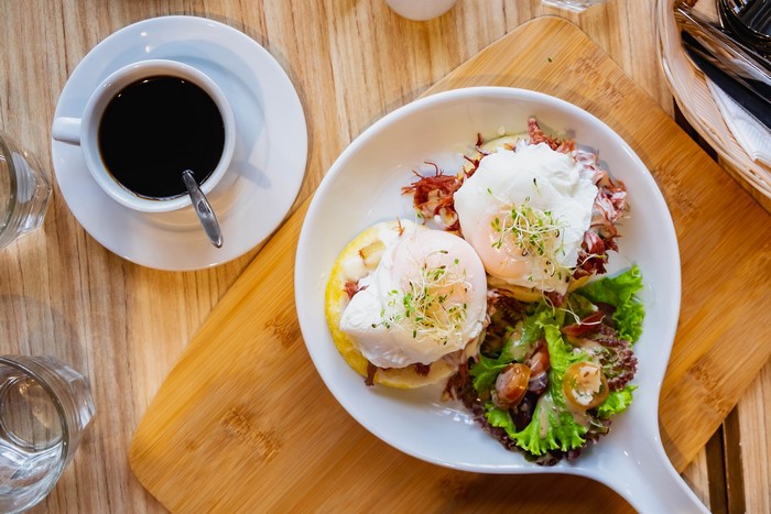 Poached eggs with salad and coffee