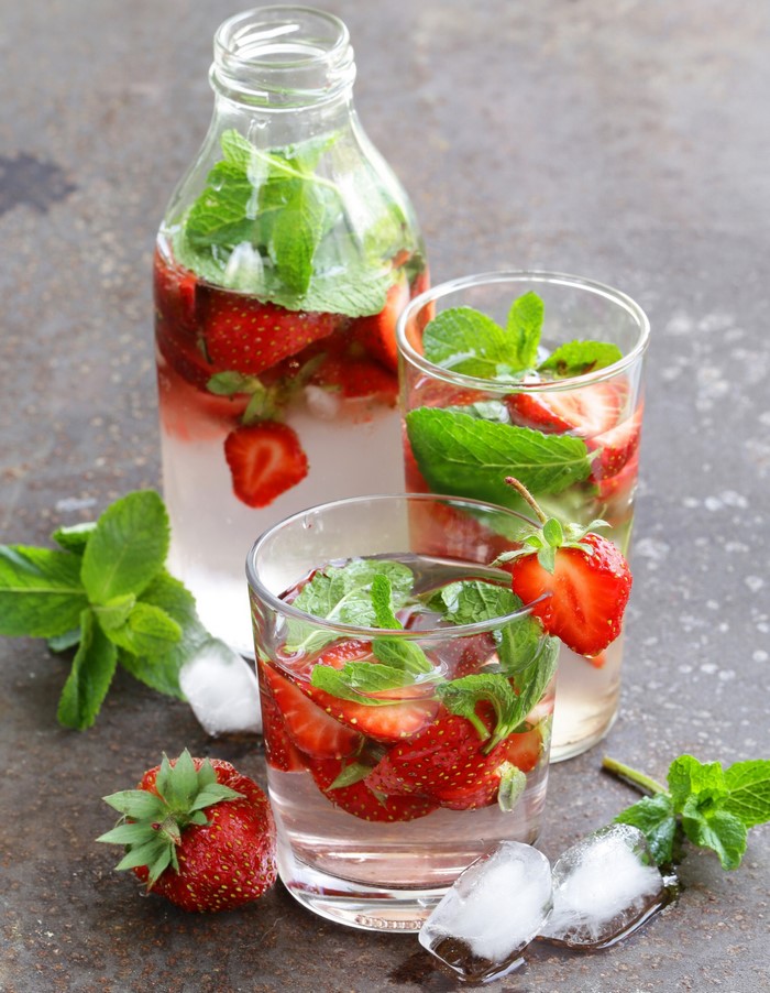 Strawberry and mint infused water in bottle and glasses