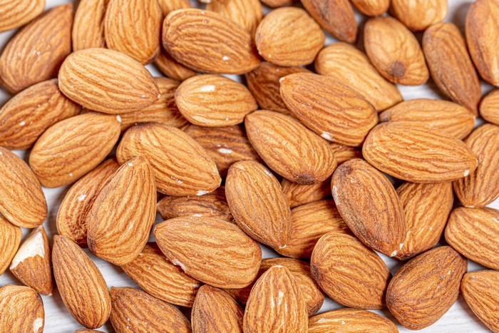 A pile of almonds with textured shells
