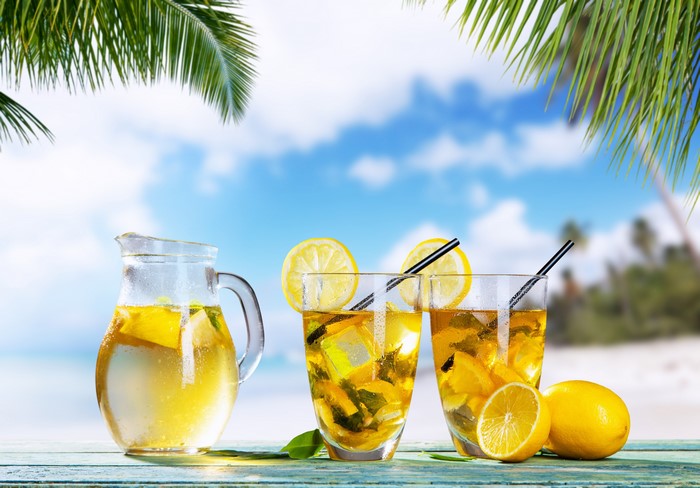 Lemonade pitcher and glasses on a beach
