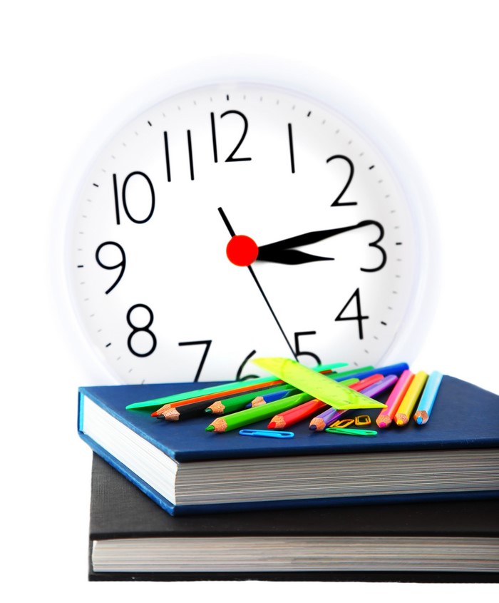 Clock and school supplies on books