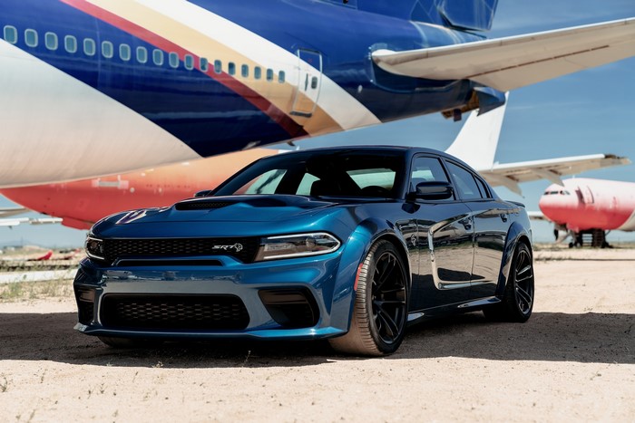 Blue Dodge Charger SRT Hellcat in front of airplanes