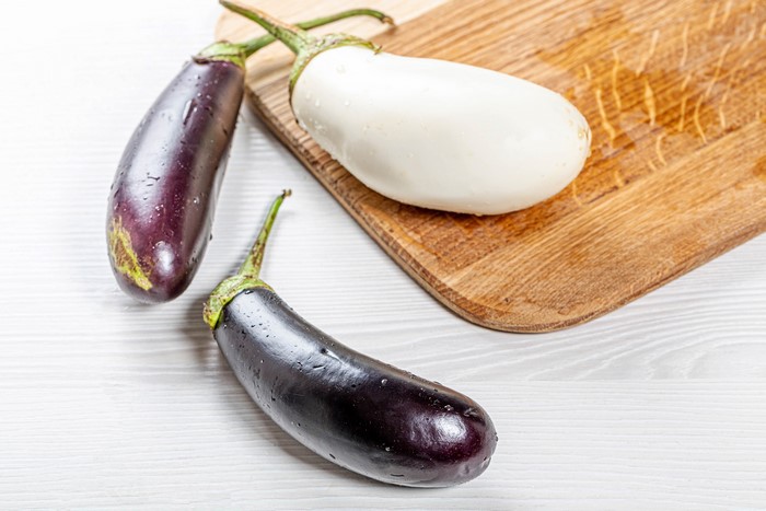 Three eggplants on a cutting board