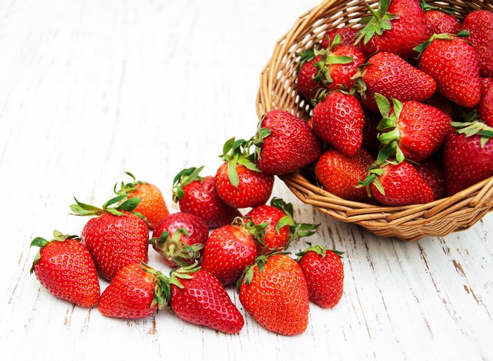 Strawberries spilling from a wicker basket