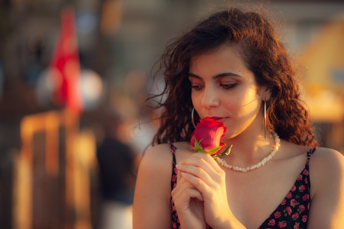 Woman smelling a red rose