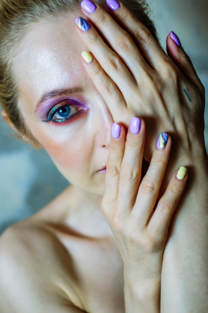 Woman with colorful eye makeup and manicure