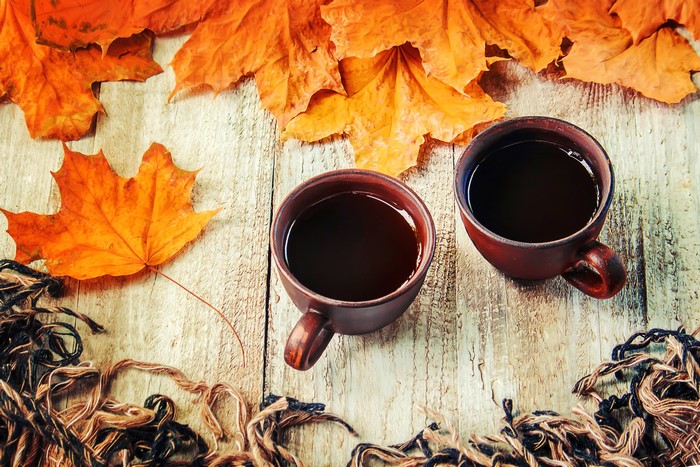 Two Mugs of Coffee with Autumn Leaves