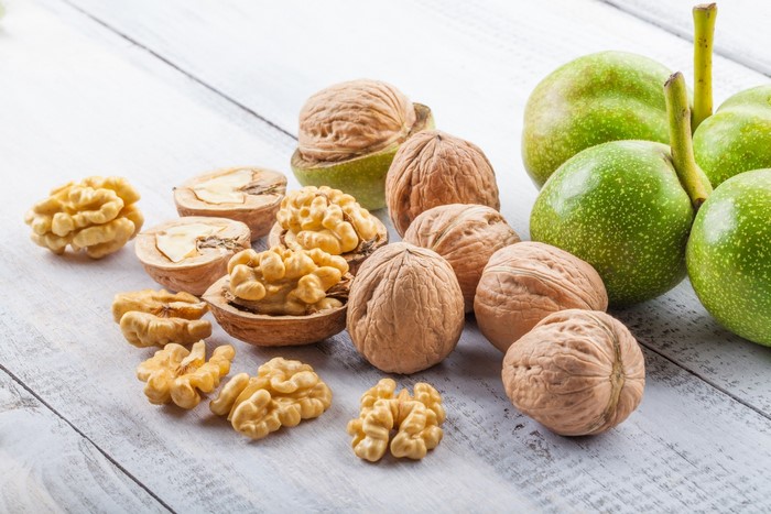 Walnuts and green walnuts on a wooden table