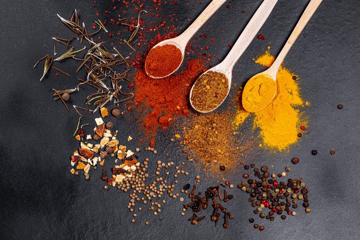 Spices on a black background with spoons
