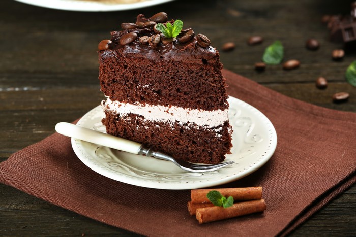 Chocolate cake slice with coffee beans and mint