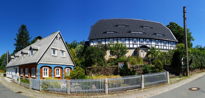 Traditional houses in Wehrsdorf, Germany with a street and fence