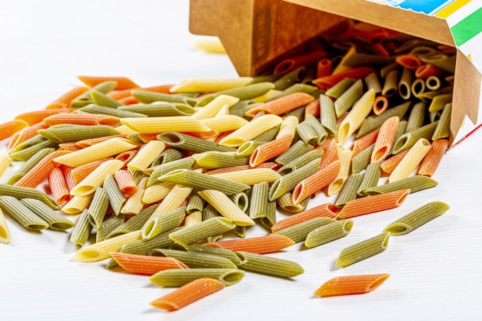 Tricolor Penne Pasta Spilling from Cardboard Box