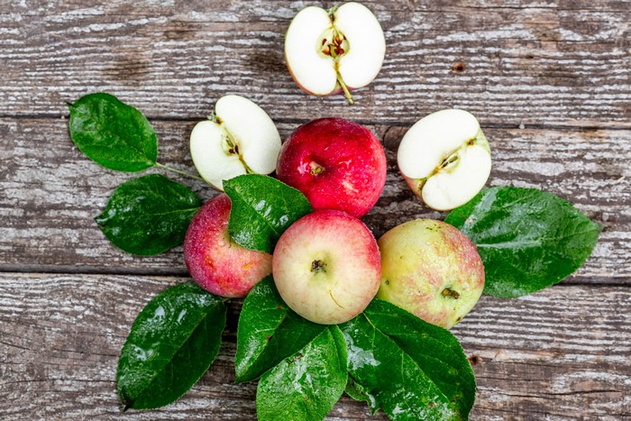 Apples and leaves on wood planks