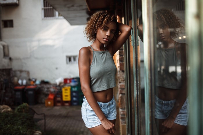 Woman in crop top and shorts posing