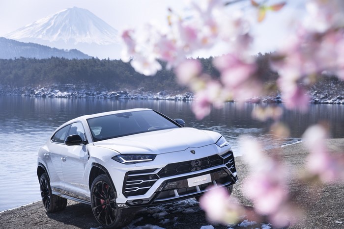 White Lamborghini Urus by a lake with Mount Fuji