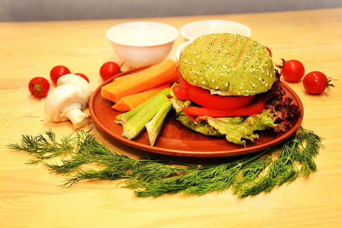Green vegan burger with vegetables and dill