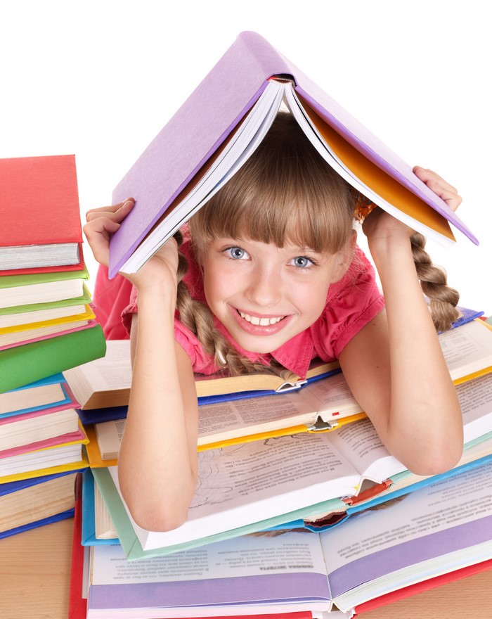Smiling Girl Holding Book Over Head with Stacks of Books