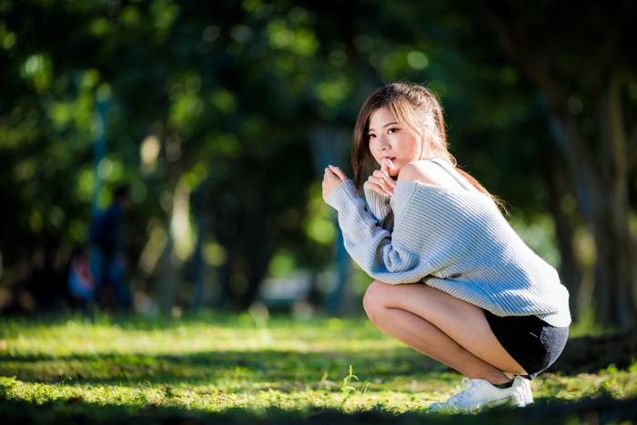 Young Woman in Sweater Sitting Outdoors in 4K