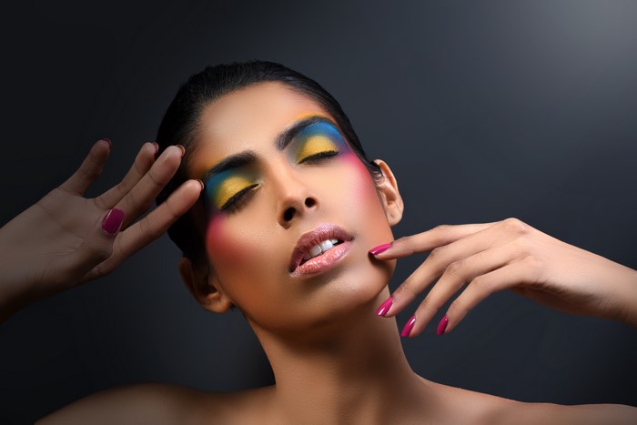 Woman with colorful makeup and manicured hands