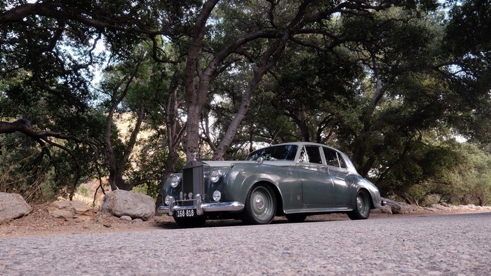 Rolls-Royce Silver Cloud parked under trees