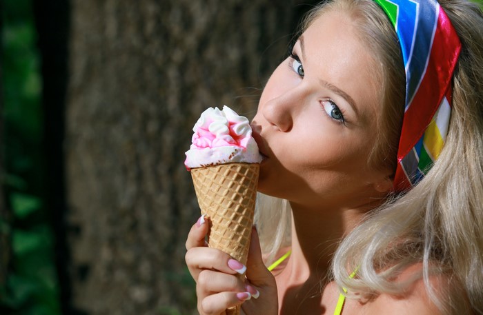 Blonde Girl Enjoying Pink and White Ice Cream Cone