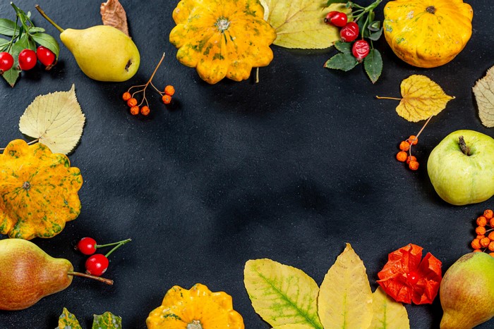 Autumn harvest arrangement with pumpkins, pears, apples, and rose hips