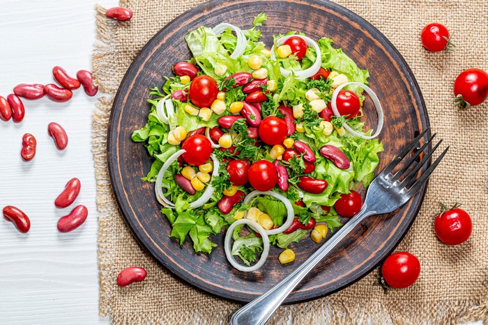Salad with kidney beans, corn, tomatoes, and onion on a plate