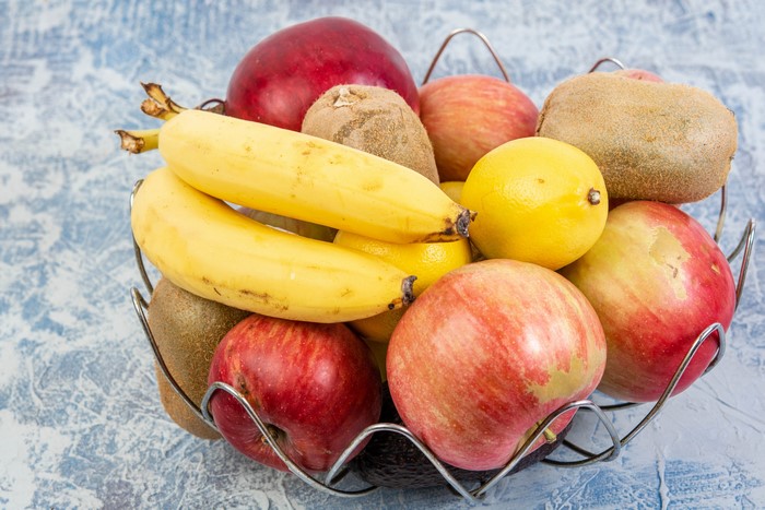 Fruit basket with apples, bananas, lemons, and kiwis