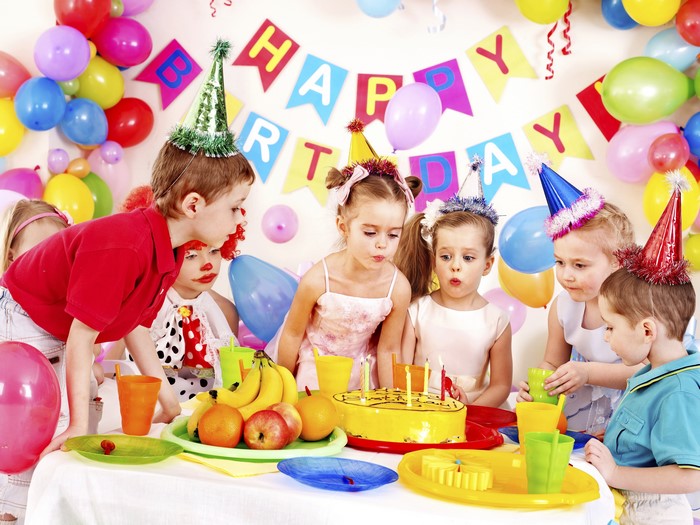 Children celebrating a birthday with cake and balloons