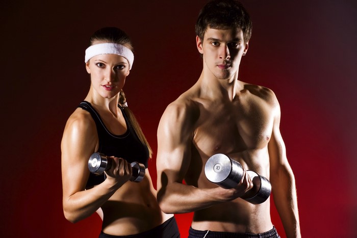 Man and woman exercising with dumbbells