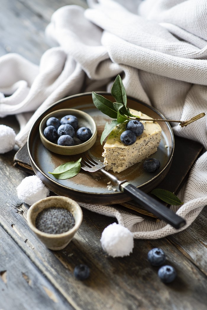 Slice of cheesecake with blueberries and poppy seeds