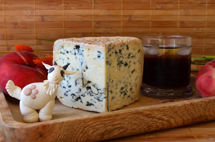 Blue cheese wedge with goat figurine and peaches