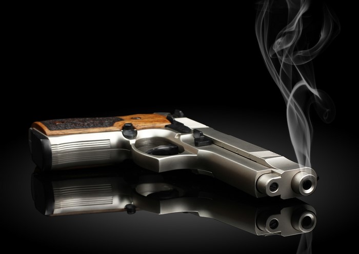 Pistol with smoke on a black background
