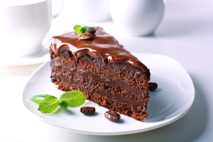 Chocolate cake slice with coffee beans and mint