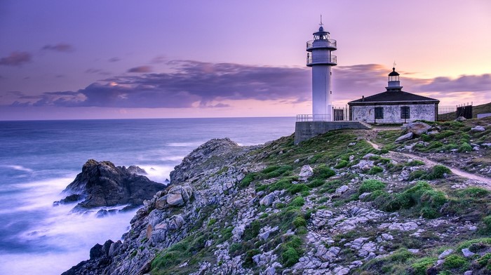 Lighthouse on a rocky coast in Spain at sunset