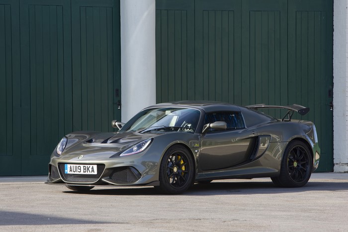 Grey Lotus Exige Sport 410 parked in front of green doors