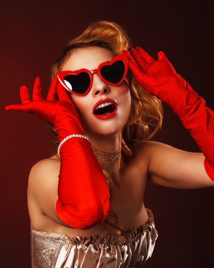 Woman in red gloves and heart-shaped sunglasses
